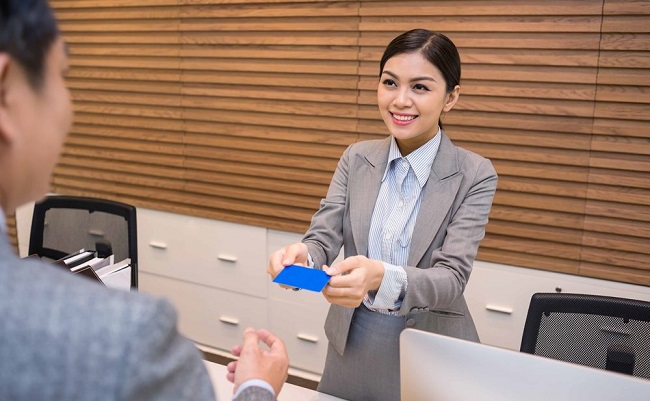 Nhân viên lễ tân khách sạn làm thủ tục nhận phòng