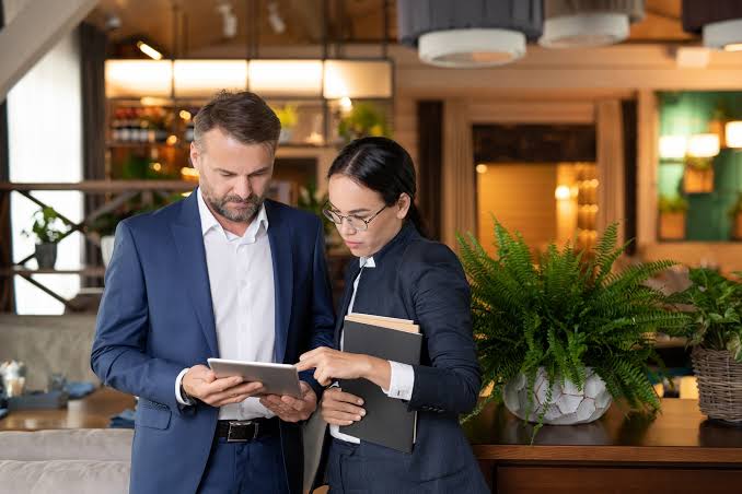 Nhân viên kinh doanh khách sạn trao đổi hợp đồng